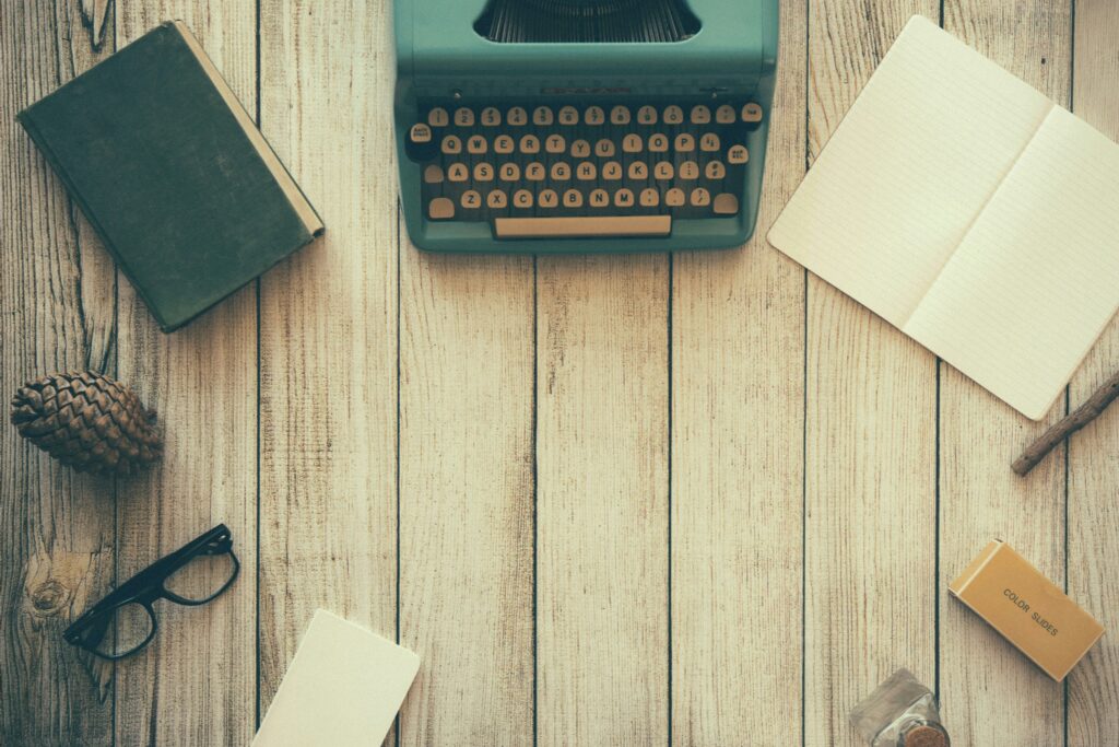 Vintage typewriter on desk with glasses and book — symbolic of faith-filled writing.